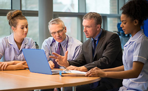 admin meeting with people sitting around a computer